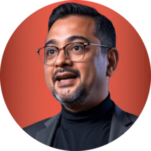 Ruhani Rabin, wearing glasses and a turtleneck, smiles in a portrait.